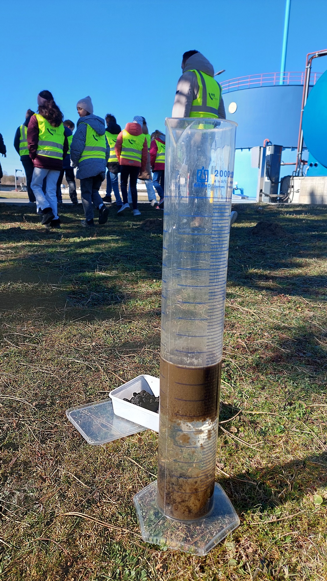 In einem Glaskolben mit Abwasser haben sich Feststoffe abgesetzt