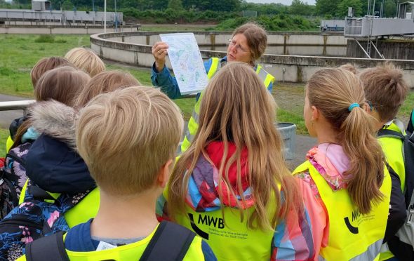 Eine Umweltpädagogin erklärt Kindern die Abwasserreinigung